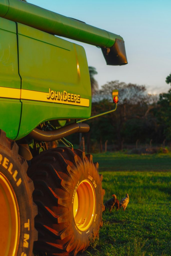 a-large-green-tractor-parked-on-top-of-a-lush-green-field-5am0ifejy7k